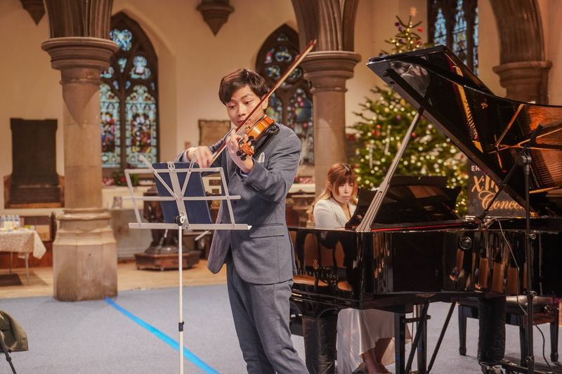 Eric Chung playing violin with a pianist accompanying on a Steinway grand